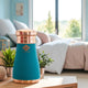 Sky silk textured copper bottle with embossed logo flat screw top cap and fully concealed tumbler stored within the base