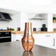 Copper kitchen shaker on a countertop with a blurred kitchen background