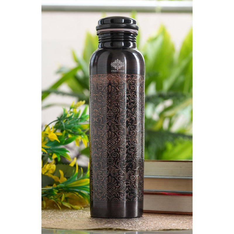 Indian Art Villa’s 900ml pure copper bottle with ornate black embossed design, blending heritage and elegance.